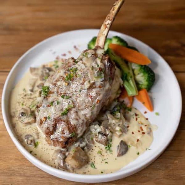 Andiamo Italian Grill's bone-in pork chop with mushroom cream sauce, broccoli, and carrots.