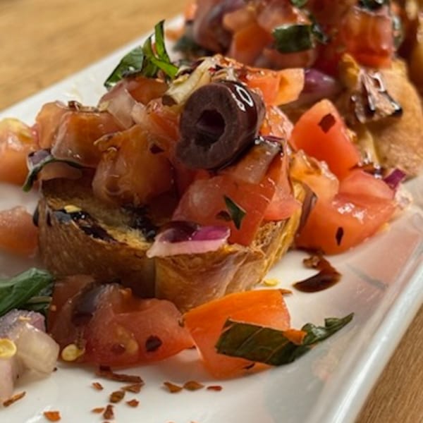 Andiamo Italian Grill's bruschetta, topped with diced tomatoes, olives, red onion, basil, and balsamic glaze.